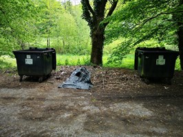 Pojemniki na śmieci stoją z dala od grobów