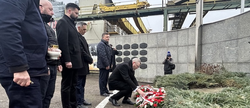 Grzegorz Braun z kwiatami pod szczecińską stocznią